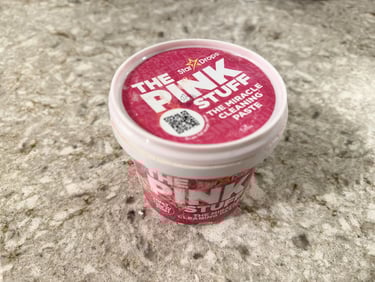The Pink Stuff cleaning paste container on a bathroom counter for toilet cleaning