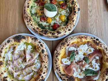 Trois pizzas napolitaines artisanales servies au restaurant Histoire sans Faim à Lausanne : burrata et tomate