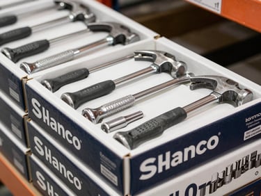 Close-up of bulk packaged professional steel claw hammers and socket sets in sturdy retail-ready boxes, high-key warehouse lighting, sharp focus, 35mm