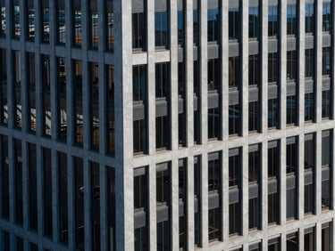 High-angle architectural view of modern corporate office building in St. Petersburg, sharp structural shadows, crisp daylight, cool blue tones.