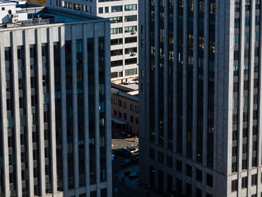High-angle architectural lines of modern corporate offices in St. Petersburg, sharp shadows, cool high-contrast daylight, deep blue and charcoal tones, 35mm lens