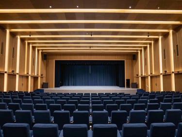 Extreme wide-angle cinematic shot of a massive, empty corporate summit hall in Dubai, architectural lighting casting sharp gold lines on navy blue seating, pristine stage setup before doors open.