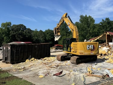Excavator loading materials on a residential demolition site