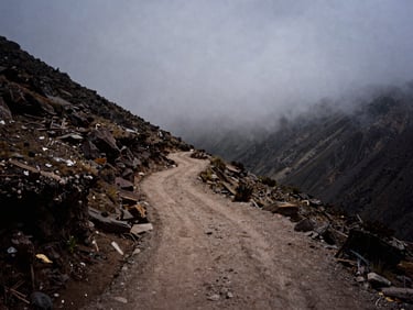 Mist-shrouded high-altitude Andean trail, quiet mountain silence, dramatic shadows, documentary style