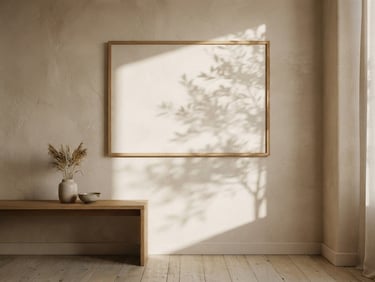 Straight-on architectural shot of a minimalist sunlit room, empty wooden frame on a textured plaster wall, soft morning shadows cast by foliage, beige and powder pink tones, 35mm