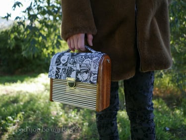 a woman in a coat holding wooden bag made from mahogany wood, bamboo sticks and comic fabric
