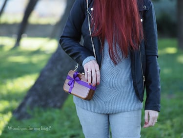 a woman with red hair and mahogany wood clutch decorated with purple satin bow