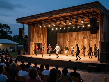 Wide environmental shot of an open-air theatre performance in Lomé at dusk, actors in motion on a raised wooden stage, audience silhouettes in the foreground, warm amber stage lighting cutting through the blue evening