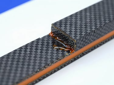 Cross-section of a cured carbon fiber composite material bonded with high-performance epoxy resin, showing perfect fiber wet-out