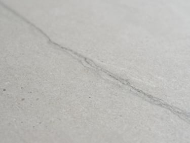 Macro detail of subtle grey veining in an engineered quartz surface, soft diffused side-light, sharp focus, 35mm lens, architectural interior photography