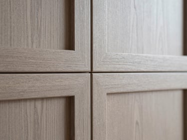 Close-up macro shot of perfectly grain-matched wooden cabinetry, showing fine detail and texture, diffused side-light.