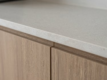 Macro detail of a seamless joint where engineered quartz countertop meets architectural wood paneling, zero-tolerance fit, soft diffused side-light, sharp focus, 35mm lens, architectural interior photography