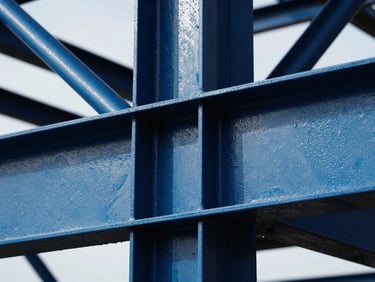 Industrial steel structure under heavy marine spray, showing high-contrast water repulsion on treated surfaces.