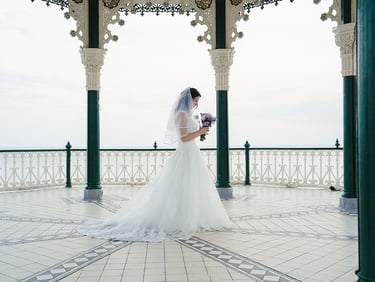 Bride holding her flowers and standing in her dress
