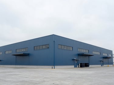 Wide environmental shot of a modern industrial logistics facility, clean architectural lines, overcast sky