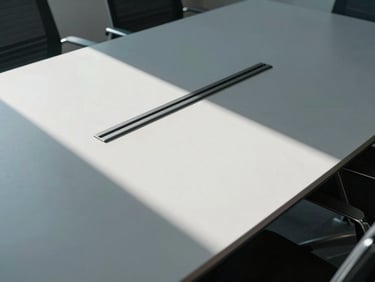 Overhead clean desk setup in a minimalist corporate boardroom, sharp daylight casting geometric shadows, desaturated tones.