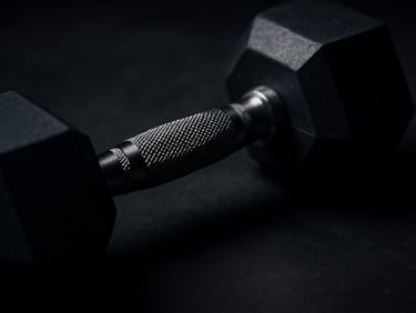 Close-up of a premium rubber hex dumbbell on a clean dark floor, dramatic low-key lighting, focus on the textured grip.