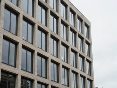 Architectural lines of a modern Parisian office building facade, clean concrete and glass, soft overcast daylight.