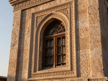 Close-up of an ornate Mardin stone konak window with carved limestone surround, soft morning light from the left, warm ochre tones, no people