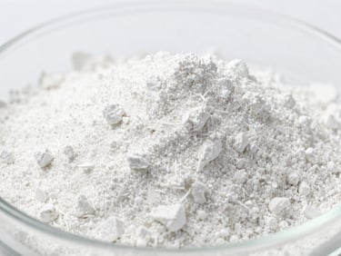 Macro shot of fine white mineral powder in a laboratory dish, under bright high-key lighting, sharp focus on texture, minimalist composition, 35mm