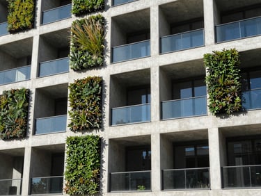 Close-up of a sustainable building facade detail, showing integrated green wall elements and efficient glazing, sharp light.