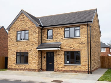 Crisp architectural exterior of a completed brick wrap-around home extension in Didsbury, matching original brickwork, bright overcast daylight, sharp focus