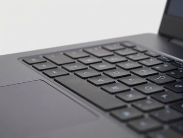 Close-up of a high-performance gaming laptop keyboard with subtle backlighting, clean studio lighting, light gray background, sharp details