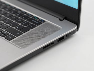 Close-up macro shot of a gaming laptop's ventilation grille and RGB keyboard detail, crisp studio lighting, clean light gray background, sharp details, high-contrast, 85mm lens