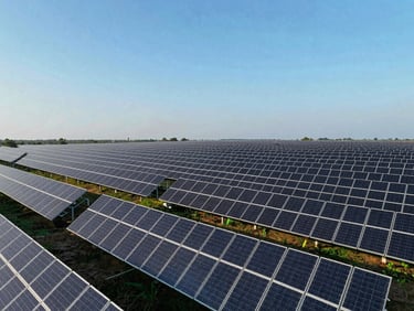 Aerial photography of modern solar panels stretching across South Indian terrain, blue skies, high-contrast crisp daylight, clean geometric lines
