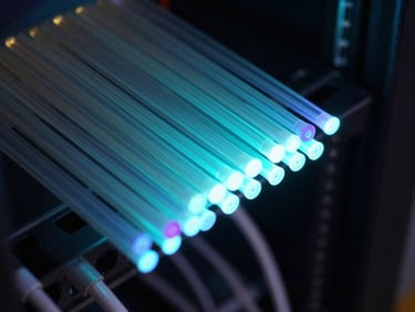Macro shot of glowing optical fibers in a server rack, sharp cyan and violet edge-lighting, dark slate tones, macro depth of field