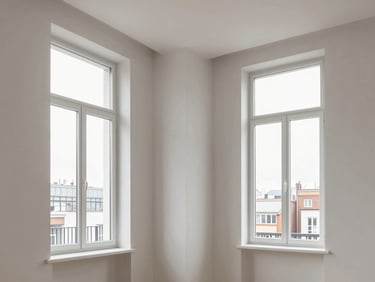 Crisp interior photography of an Ixelles apartment, immaculate white gypsum walls, sharp ceiling angles, natural light pouring through tall windows.