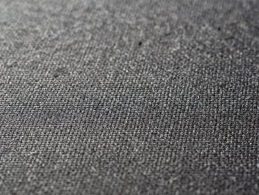 Extreme close-up of fine textile weave, individual threads visible, soft diffused light revealing texture and shadow depth, spare composition with generous negative space at left