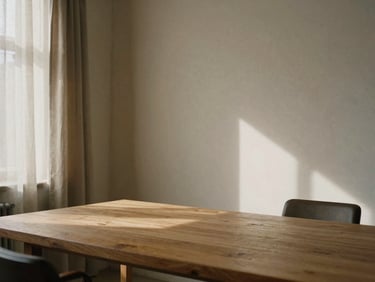 Tactile detail shot of a minimalist office interior, a large oak table, linen curtains, soft daylight casting gentle shadows on a plaster wall, warm editorial style