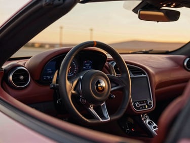 Close-up of a luxury sports car steering wheel and leather dashboard, warm ambient dashboard lighting, 35mm photography.