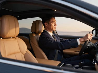 Interior of a luxury sedan, leather seats, soft ambient lighting, a professional chauffeur's hand on the steering wheel, crisp commercial lighting