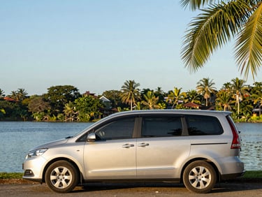 Modern silver minivan parked by a scenic lake in Nicaragua, clear sky, warm golden hour light.