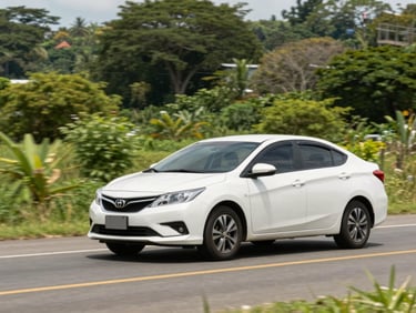 Clean white sedan driving on a well-maintained road with lush green Nicaraguan scenery, bright natural daylight.