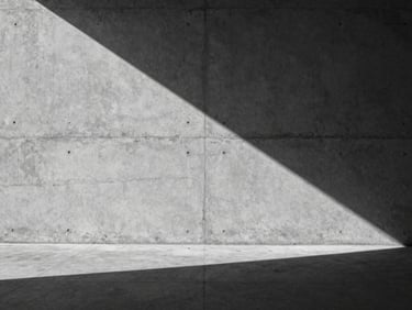 Wide environmental shot of an empty concrete gallery wall with a single sharp shadow falling diagonally, high-contrast sunlight, 35mm desaturated.