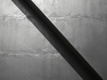 Abstract geometric composition of brushed steel panels intersecting, sharp focus, hard sunlight reflections, desaturated monochrome tones.