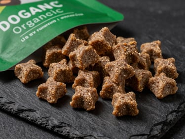 Close-up studio shot of premium organic dog treats on a dark textured slate background, rich green accents, sharp focus, 50mm lens