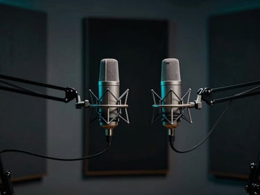 High-end professional podcast studio setup, dual broadcast microphones on boom arms, sound-dampened walls with moody dark shadows, subtle cool teal rim lighting, cinematic depth of field, 50mm lens