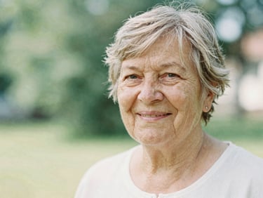 Warm portrait of a senior Lithuanian female intellectual smiling, soft natural daylight, shallow depth of field