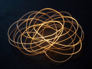 Abstract image of a chaotic, restless mind symbolized by tangled, glowing lines on a dark background, with deep navy and gold tones, shallow depth of field, 35mm.