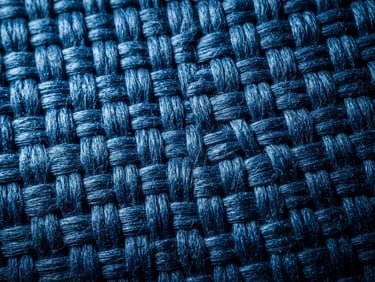 Macro detail shot of high-tensile blue polypropylene woven fabric texture, sharp industrial 50mm lens, dramatic side-lighting highlighting the dense load-bearing weave.