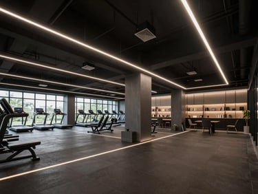 Architectural wide angle of a modern dark-themed multi-space hub, sleek LED lines dividing a fitness gym zone and a quiet study lounge, premium athletic-tech aesthetic, atmospheric lighting.