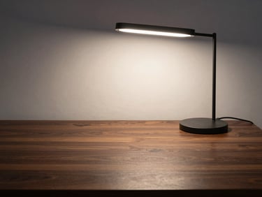 Quiet study desk with a minimalist task light, dark wood textures, soft focused lighting, peaceful study environment.