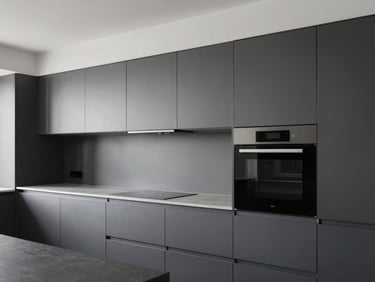 High-end modular kitchen interior with clean lines and integrated appliances, cool daylight, charcoal and steel gray palette.
