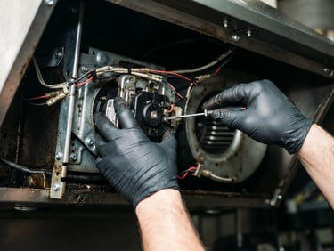 Close-up of a technician's hands expertly replacing a motor part in a kitchen chimney, bright utility lighting, high-contrast industrial tones, clean depth of field, 35mm