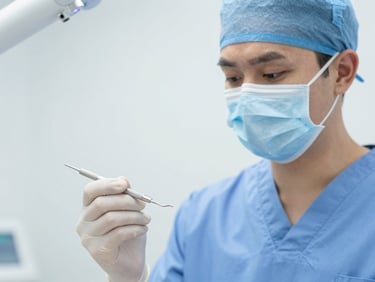 Reassuring dentist in scrubs holding a sterile dental tool, medium close-up, calm and capable.