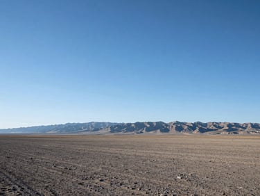 Expansive undeveloped land, clear Idaho sky, distant mountains, sense of open space and potential.